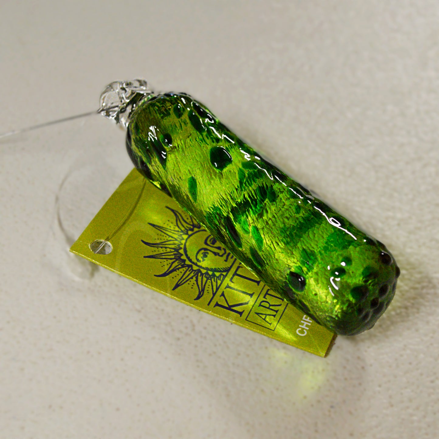 Celebrate the holiday season by starting a tradition sure to become a holiday favourite for all ages. When decorating the tree hide this glass pickle somewhere in the branches- then on Christmas morning or another time of your choosing - gather everyone and the first person to find the hidden pickle receives an extra present, or opens the first present, your choice! Made by Kitras Art Glass
