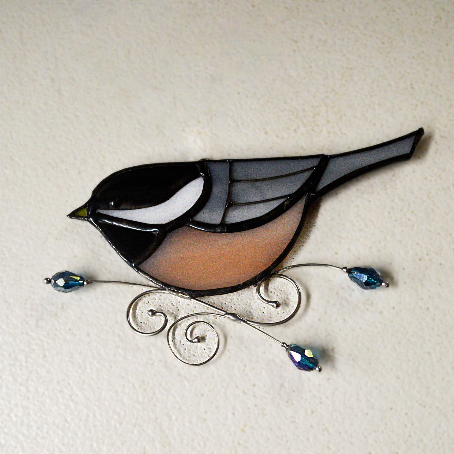 This adorable chickadee stained glass suncatcher is a great for window decoration, as a gift and more! Hang it up in your window to see the full beauty of the stained glass, add it to a floral arraignment, or use it as a gift for the nature lover in your life.   All stained glass is handmade by Deb's Broken glass in Bathurst NB. 