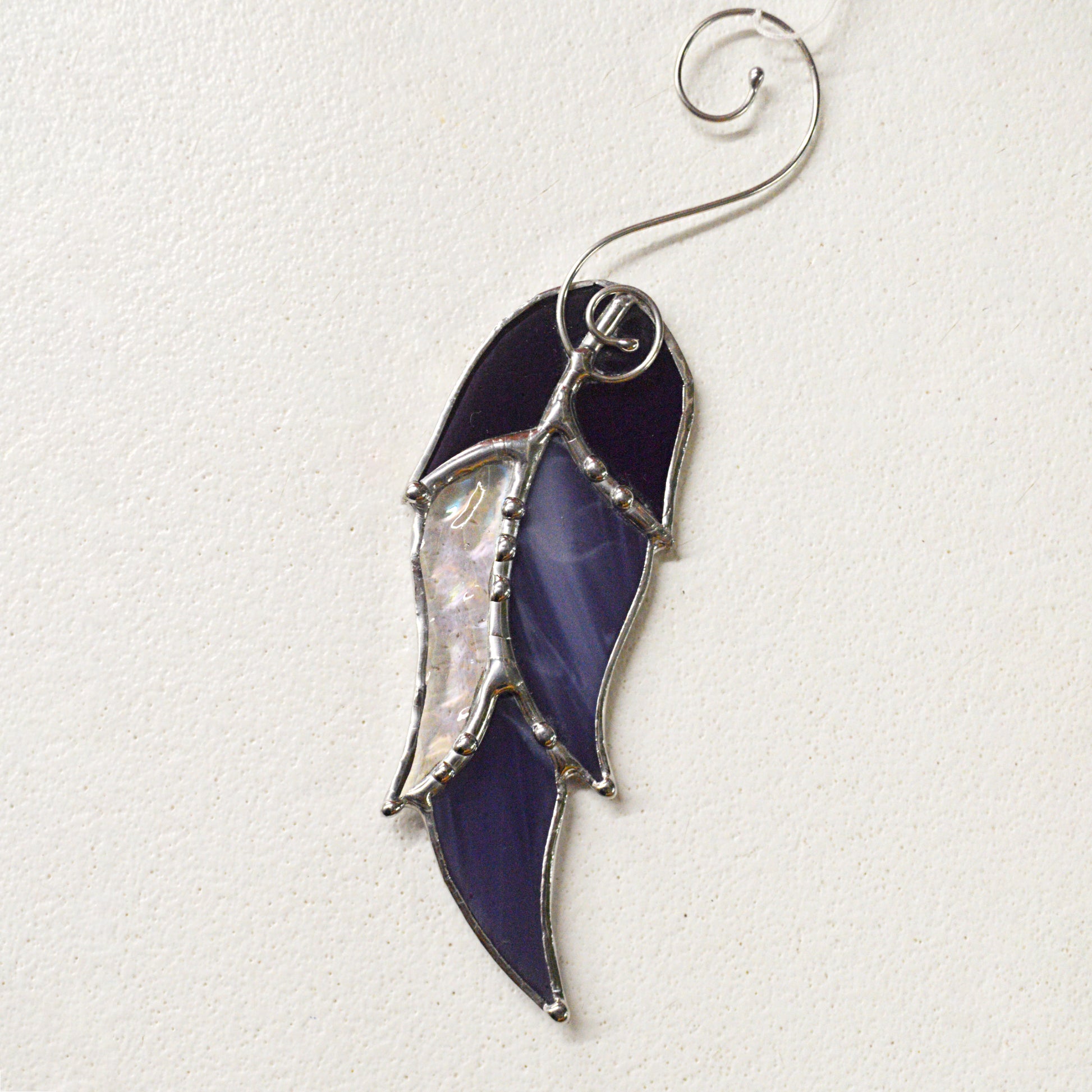 This feather shaped stained glass suncatcher is a great for window decoration, as a gift and more! Hang it up in your window to see the full beauty of the stained glass, add it to a floral arraignment, or use it as a gift for the nature lover in your life.   All stained glass is handmade by Deb's Broken glass in Bathurst NB.  